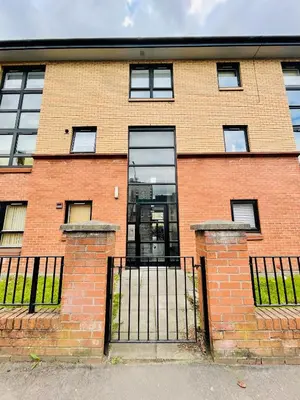 a brick building with a gate in front of it at Modern 2 bedroom Apartment Near City Centre in Glasgow