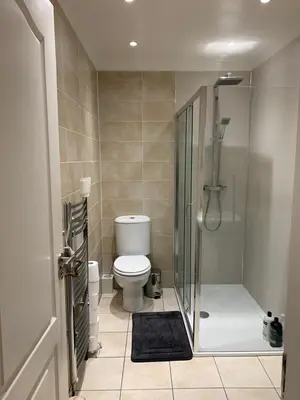 a bathroom with a toilet and a glass shower at Dunfermline GF flat, 5 min walk to Train St. and High St. in Dunfermline