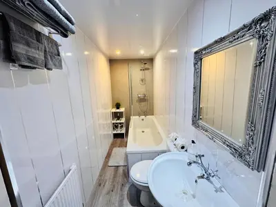 a white bathroom with a sink and a tub at THE LION’S REST - BOUTIQUE APARTMENT SUITE. in Port Glasgow