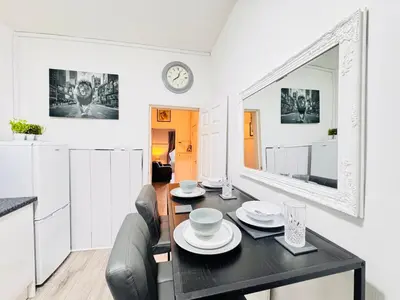 a dining room with a table and chairs and a mirror at THE LION’S REST - BOUTIQUE APARTMENT SUITE. in Port Glasgow