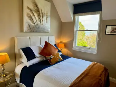 a bedroom with a bed with pillows and a window at Loch View at Lomond Castle in Balloch
