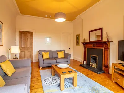 a living room with a couch and a fireplace at Beautiful and Bright Georgian Style Morningside Apartment - Pass the Keys in Edinburgh