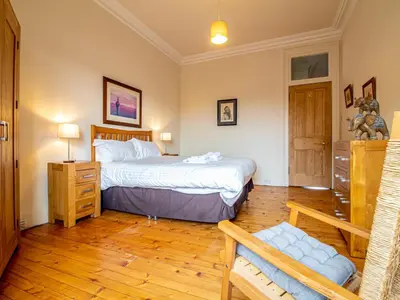 a bedroom with a bed and a wooden floor at Beautiful and Bright Georgian Style Morningside Apartment - Pass the Keys in Edinburgh
