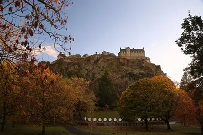 a castle on top of a mountain with trees at Beautiful and Bright Georgian Style Morningside Apartment - Pass the Keys in Edinburgh