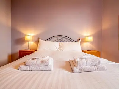 a bedroom with a white bed with towels on it at Beautiful and Bright Georgian Style Morningside Apartment - Pass the Keys in Edinburgh