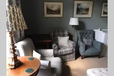 a living room with chairs and a table and a lamp at Chesthill House and Estate, Glen Lyon in Aberfeldy