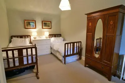 a bedroom with two beds and a dresser at Chesthill House and Estate, Glen Lyon in Aberfeldy