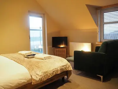 a bedroom with a bed and a chair and a television at Argyll Hotel in Bellochantuy