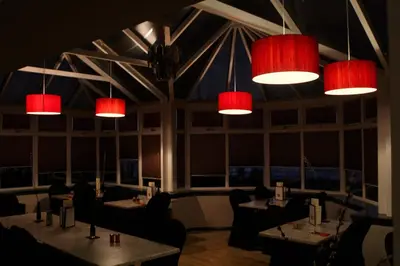 a restaurant with tables and chairs and red lights at Argyll Hotel in Bellochantuy