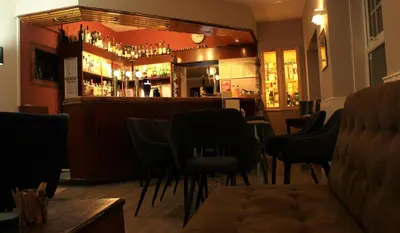 a bar with a bunch of chairs in a room at Argyll Hotel in Bellochantuy
