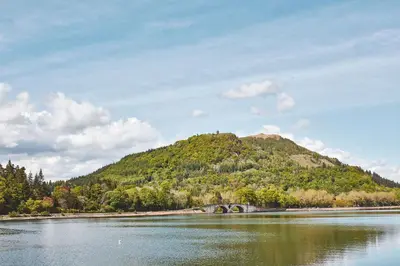 a mountain with a bridge over a body of water at Brambles of Inveraray in Inveraray