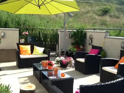 a patio with chairs and an umbrella and a table at Craig Park House in Airdrie