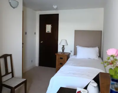 a bedroom with a bed and a chair and a table at Crinan Hotel in Crinan