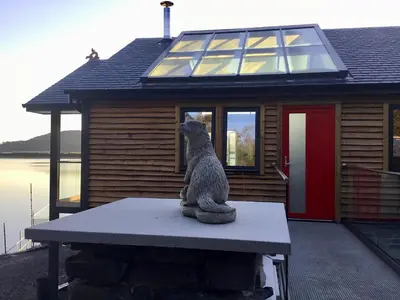 a statue of a dog sitting on a table in front of a house at Tidereach - Otters View in Connel