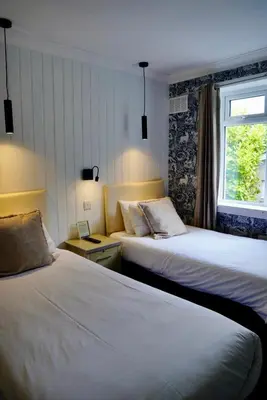 a hotel room with two beds and a window at Lochnell Arms Hotel in Oban