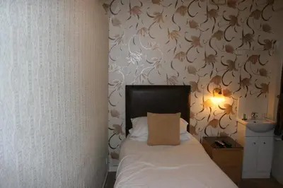 a bedroom with a bed and a wall with flowers at Royal Hotel in Girvan