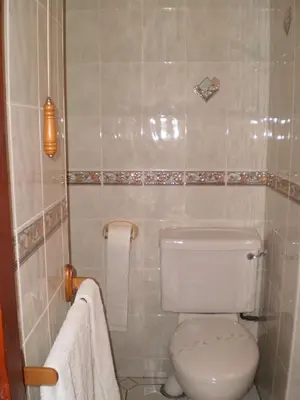 a bathroom with a toilet and towels in it at Shawlee Cottage in Airdrie