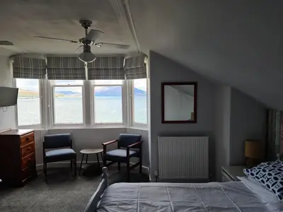 a bedroom with a bed and two chairs and a table at St.Ebba B&B in Rothesay
