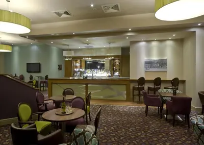 a restaurant with tables and chairs and a bar at The Glenburn Hotel in Rothesay