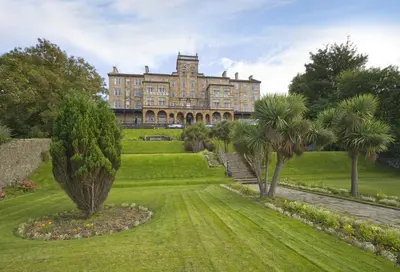 a large building with palm trees in front of it at The Glenburn Hotel in Rothesay