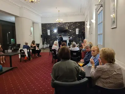 a group of people sitting at tables in a room at The Great Western Hotel in Oban