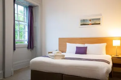 a bedroom with a large bed with purple pillows at The Great Western Hotel in Oban