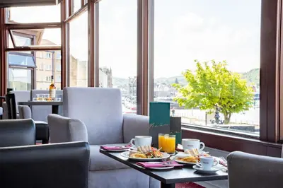 a dining room with a table with plates of food at The Great Western Hotel in Oban
