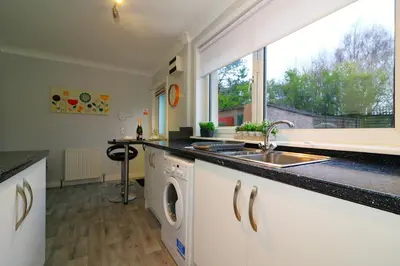 a kitchen with a sink and a washing machine at Signature - Stanfield House in Motherwell