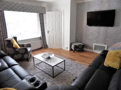 a living room with a couch and a table at Signature - Stanfield House in Motherwell