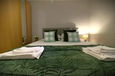 a bedroom with a bed with green sheets and pillows at Signature - Stanfield House in Motherwell