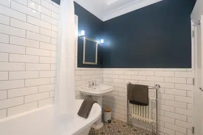 a bathroom with a sink and a toilet and a tub at Charming two bedroom, two bathroom detached cottage in Boʼness