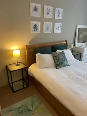 a bedroom with a bed with a lamp and pictures on the wall at Stylish City Centre Apartment in Edinburgh