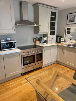 a kitchen with white cabinets and a stainless steel oven at Stylish City Centre Apartment in Edinburgh