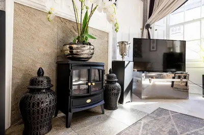 a living room with a vase on top of a tv at Elegant Flat Near Princes Street - Perfect Location, 24-7 Customer Support in Edinburgh