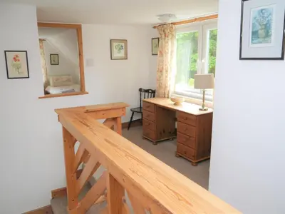 a room with a wooden desk and a window at Rowan Cottage in New Galloway