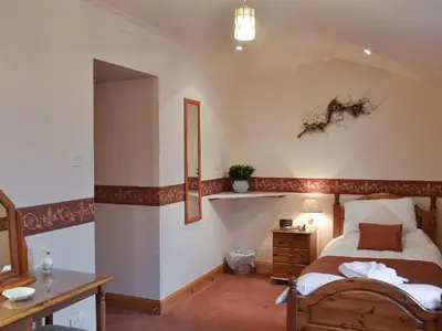 a bedroom with a bed and a desk and a mirror at West Tannacrieff in Stewarton