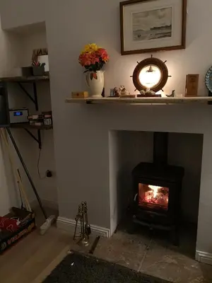 a living room with a fireplace with a fire place at Beside the Bay in Millport