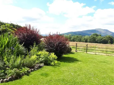 a garden with colorful plants and a fence at Ben Ledi View in Callander