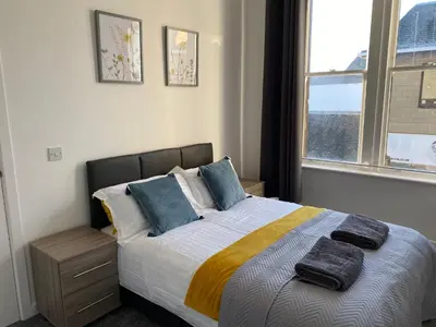 a bedroom with a bed with two towels on it at Carvetii - Edward House B - 2 Dbl bed 1st floor flat in Dunfermline