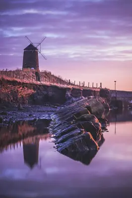 a windmill on the shore of a body of water at Carvetii - Edward House B - 2 Dbl bed 1st floor flat in Dunfermline