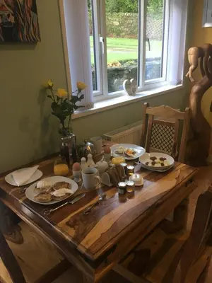 a wooden table with plates of food on it at Montague Villa in Dunoon