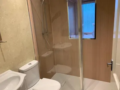 a bathroom with a shower and a toilet and a sink at 105 Nelson Street in Largs