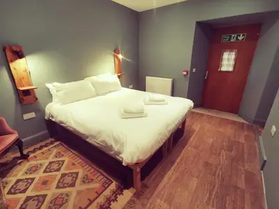 a bedroom with a large bed with white sheets at Comrie Croft in Crieff