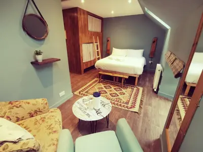 a room with a bed and a couch and a table at Comrie Croft in Crieff