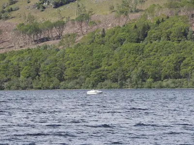 a small boat in the middle of a lake at Balmeanoch in Lochearnhead