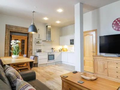 a kitchen and living room with a couch and a table at Duplex in Moffat