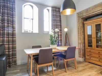 a dining room with a wooden table and chairs at Duplex in Moffat