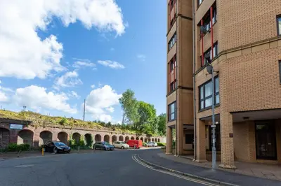 an empty street next to a brick building at Stunning 1 Bed Merchant City Apartment with Parking in Glasgow
