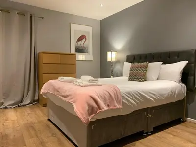 a bedroom with a large bed with a pink blanket at Stunning 2 Bed Merchant City Apartment with Residents Parking (Bell 2) in Glasgow