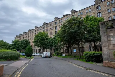 a large brick building with cars parked on a street at Stunning 2 Bed Merchant City Apartment with Residents Parking (Bell 2) in Glasgow